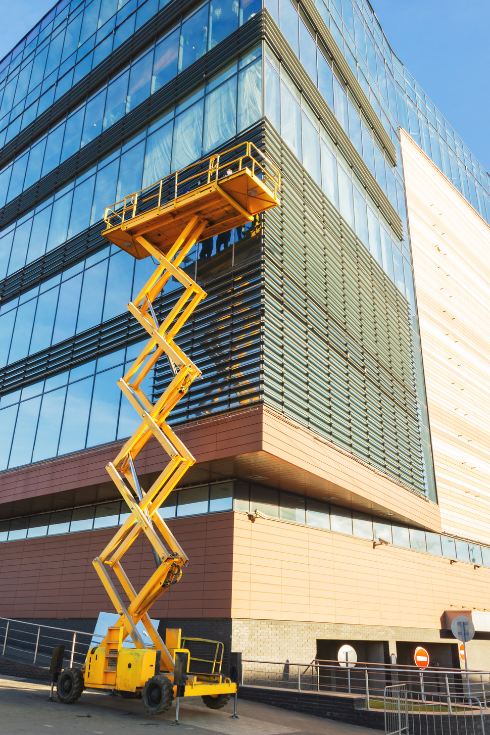 Workers on a Scissor Lift Platform at a construction site. Men at work. Scissor lift platform ensures safe operation at height